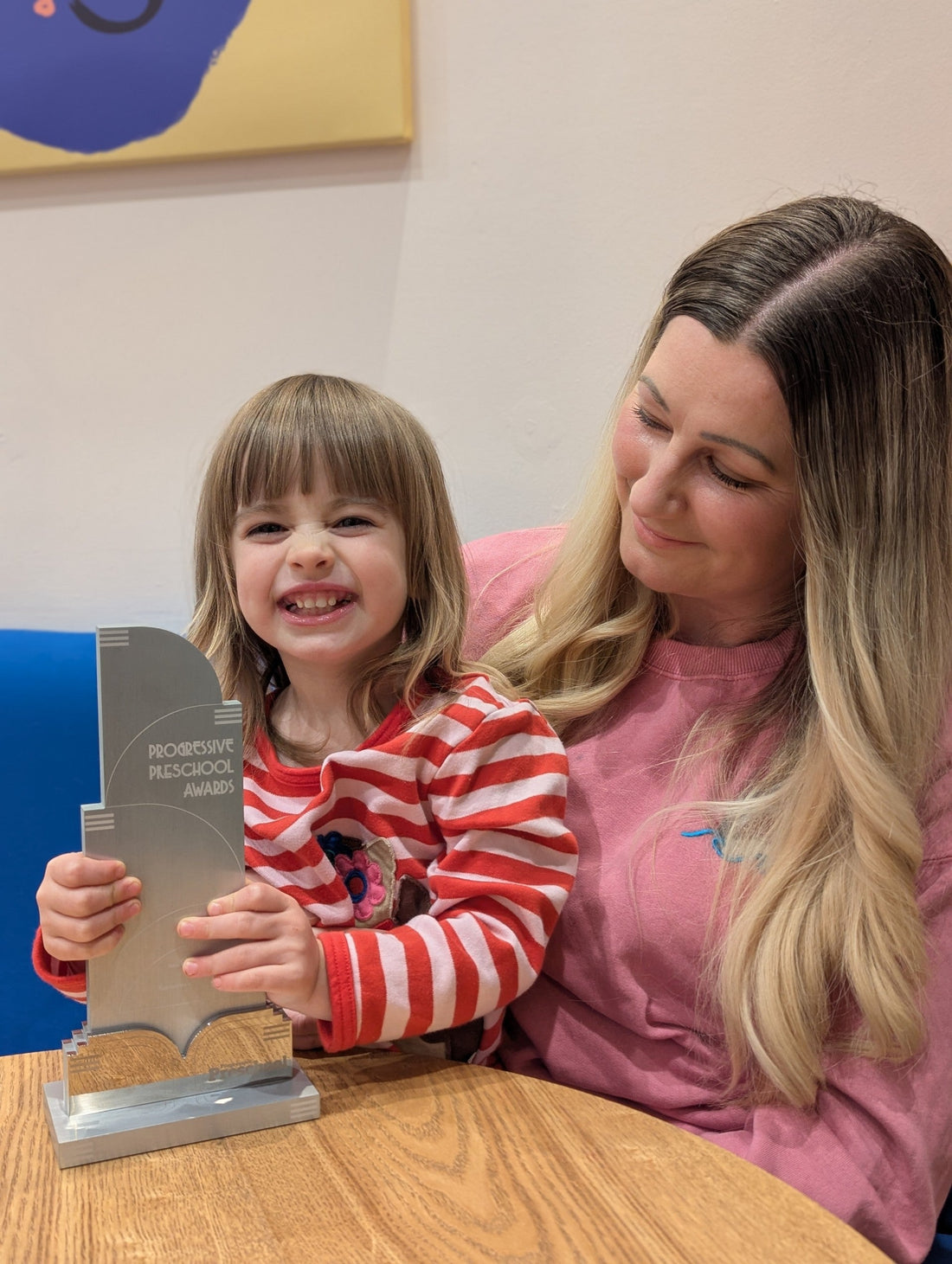 Mum and daughter holding progressive preschool award for best independent childrenswear retailer